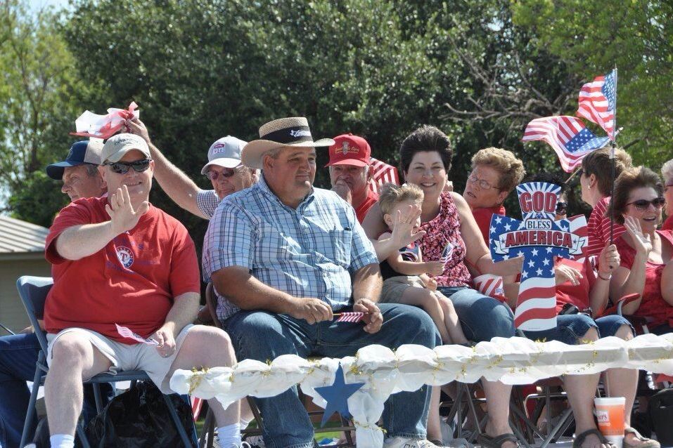 Families waving flags along the parade route