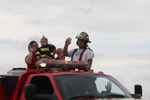 Firefighters waving from a fire truck