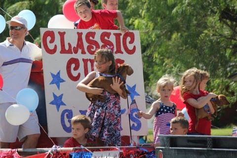 Kids waving from the Classic Cuts float