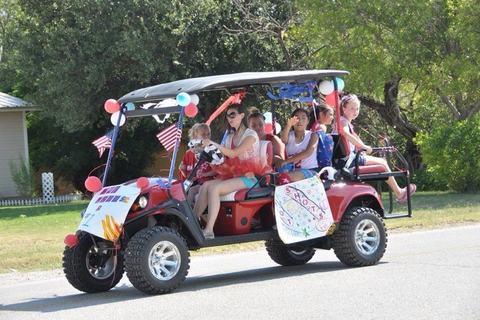 Family riding a decorated golf cart