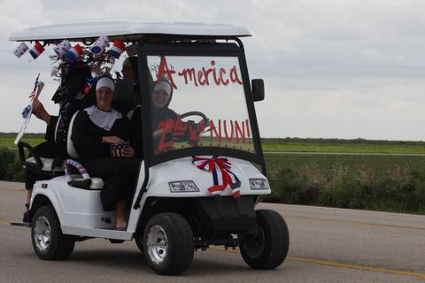 Golf cart with an America is 2nd to Nun sign
