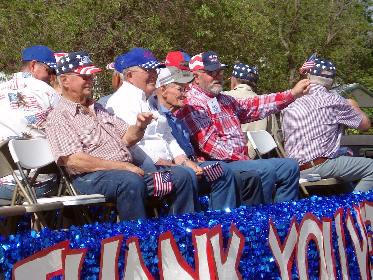 Veterans waving flags from the Veterans Float